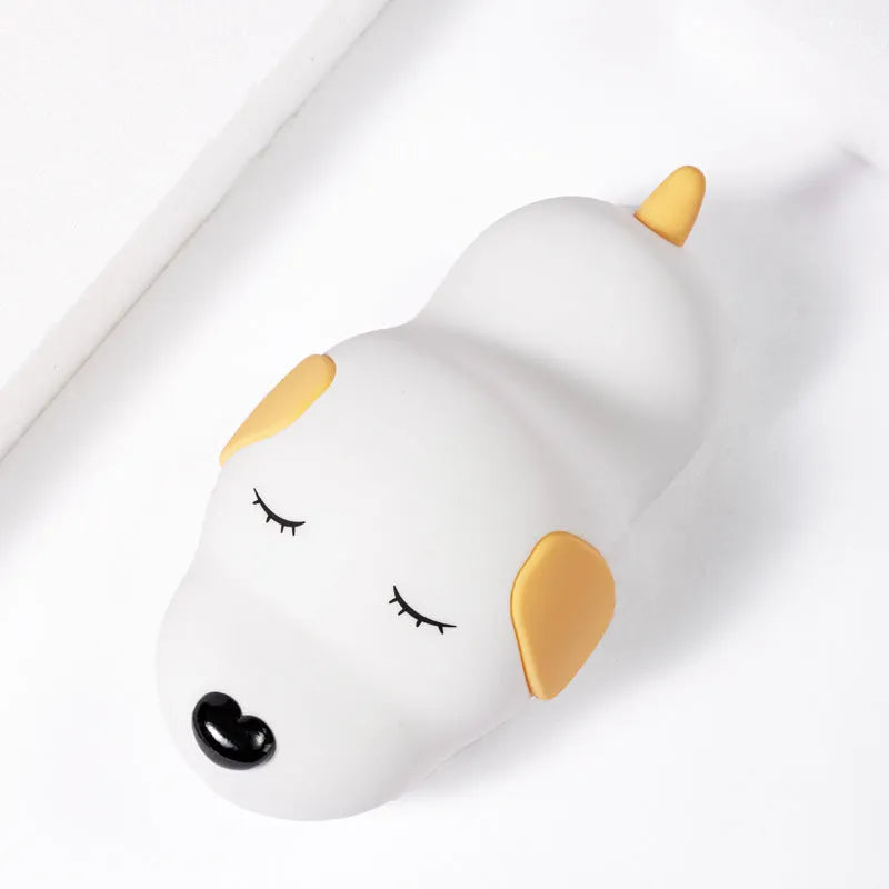 Cute two-colour silicone cartoon dog USB rechargeable night lamp on a surface.