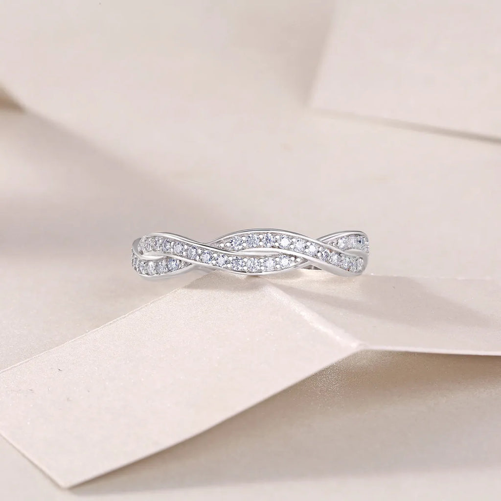 Moissanite wedding ring set in S925 silver with platinum plating on a white background