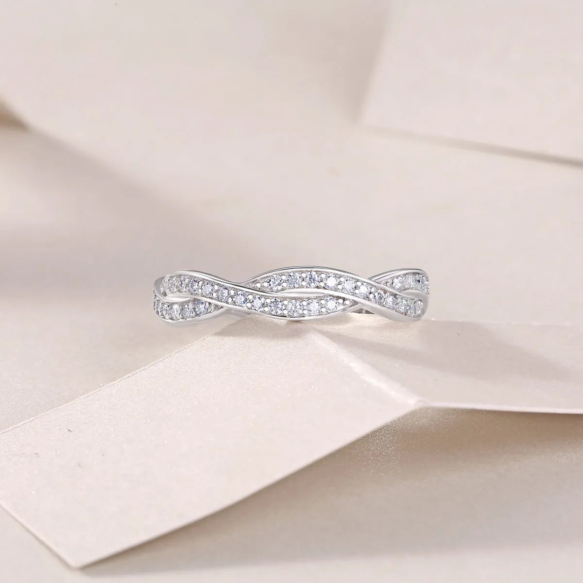 Moissanite wedding ring set in S925 silver with platinum plating on a white background