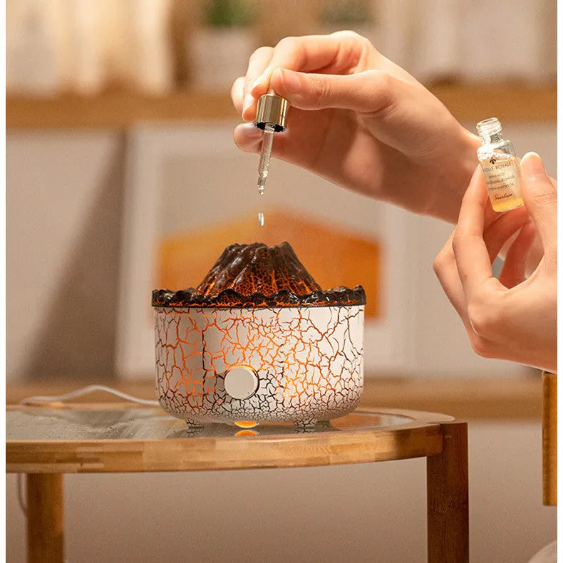 Column-shaped volcano humidifier diffuser emitting coloured mist and LED light flame effect.