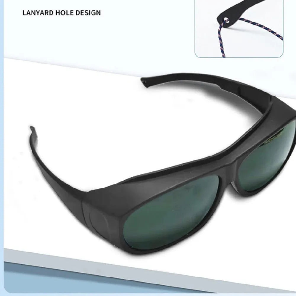 A pair of clear laser and welding safety goggles with a soft cleaning cloth on a dark background.
