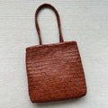 Brown handmade woven leather tote bag with a front pocket and polyester lining.