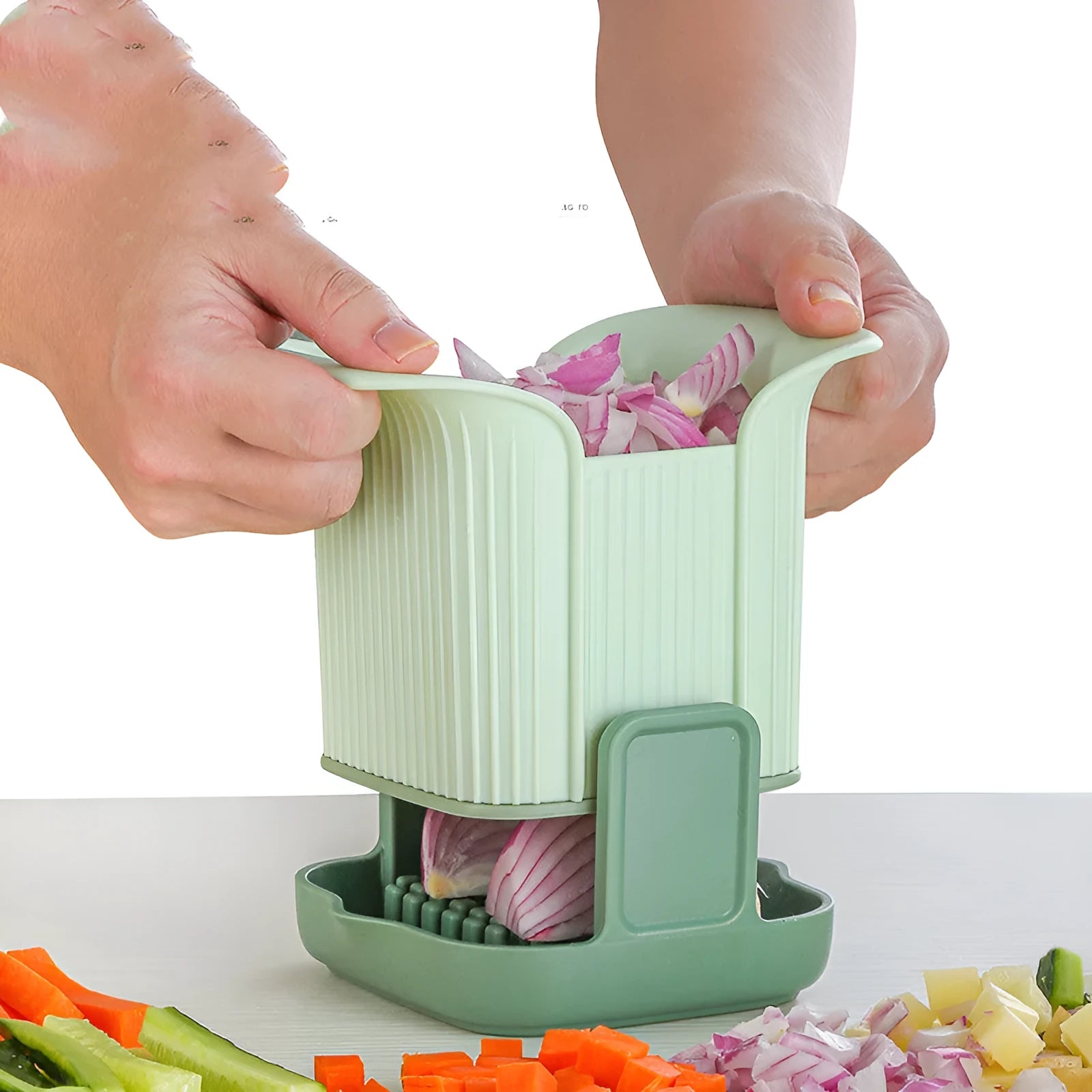 Green manual vegetable chopper with stainless steel blades for slicing potatoes and dicing onions.