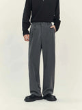 Man wearing loose straight-leg black business casual trousers made from polyester blend fabric.