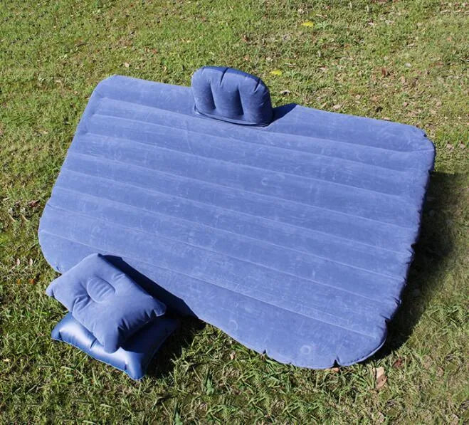 Universal inflatable car bed with flocked surface, shown with two pillows inside a vehicle.