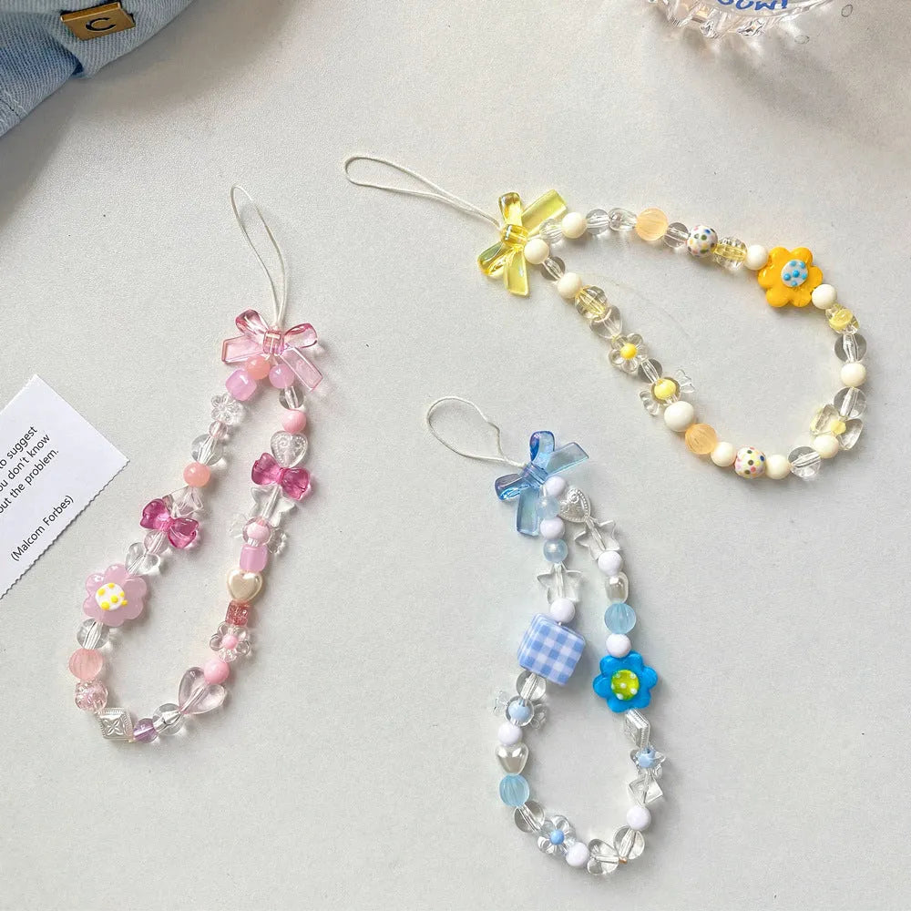 Colourful beaded flower mobile phone lanyard with a hand rope loop in blue, pink, or yellow.