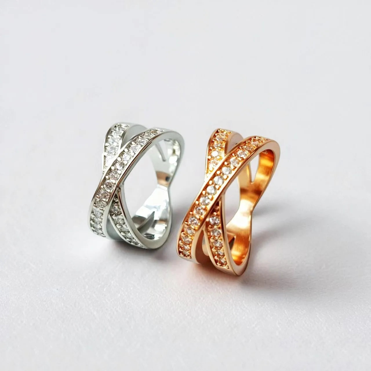 A silver or rose gold metal ring featuring a cross design with micro-inlaid zircon stones, shown in sizes 6 to 9.