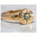 Gold-coloured star-shaped ring with a central oval zircon stone on an adjustable band.