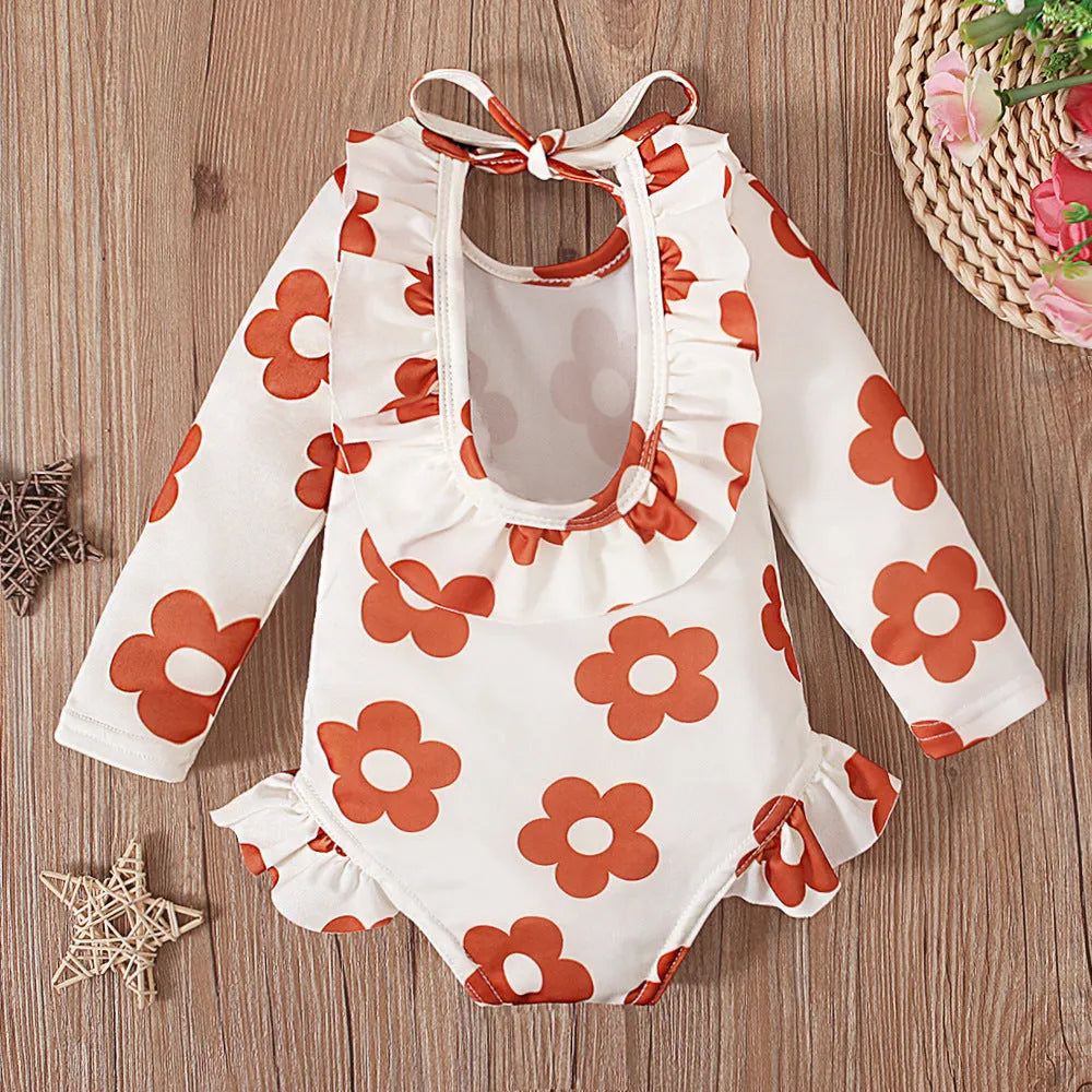 Girl's floral print open back swimsuit in orange red, shown from front and back.