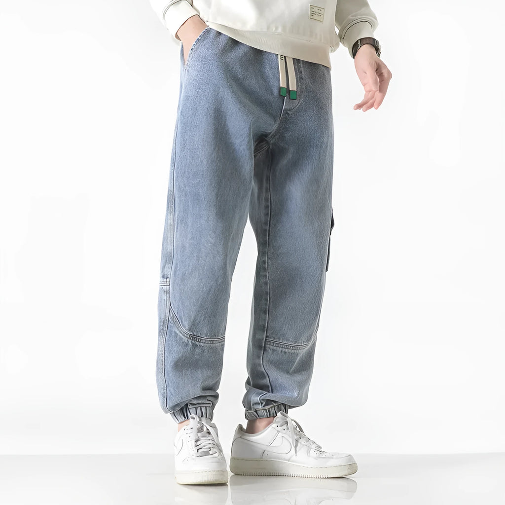 Men's loose-fit tapered cotton trousers in mid-waist design, shown in black colour.