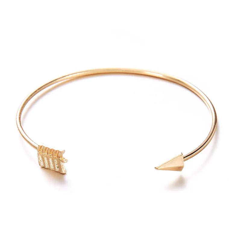 Gold women's vintage bracelet with knotted cuff design and central arrow motif