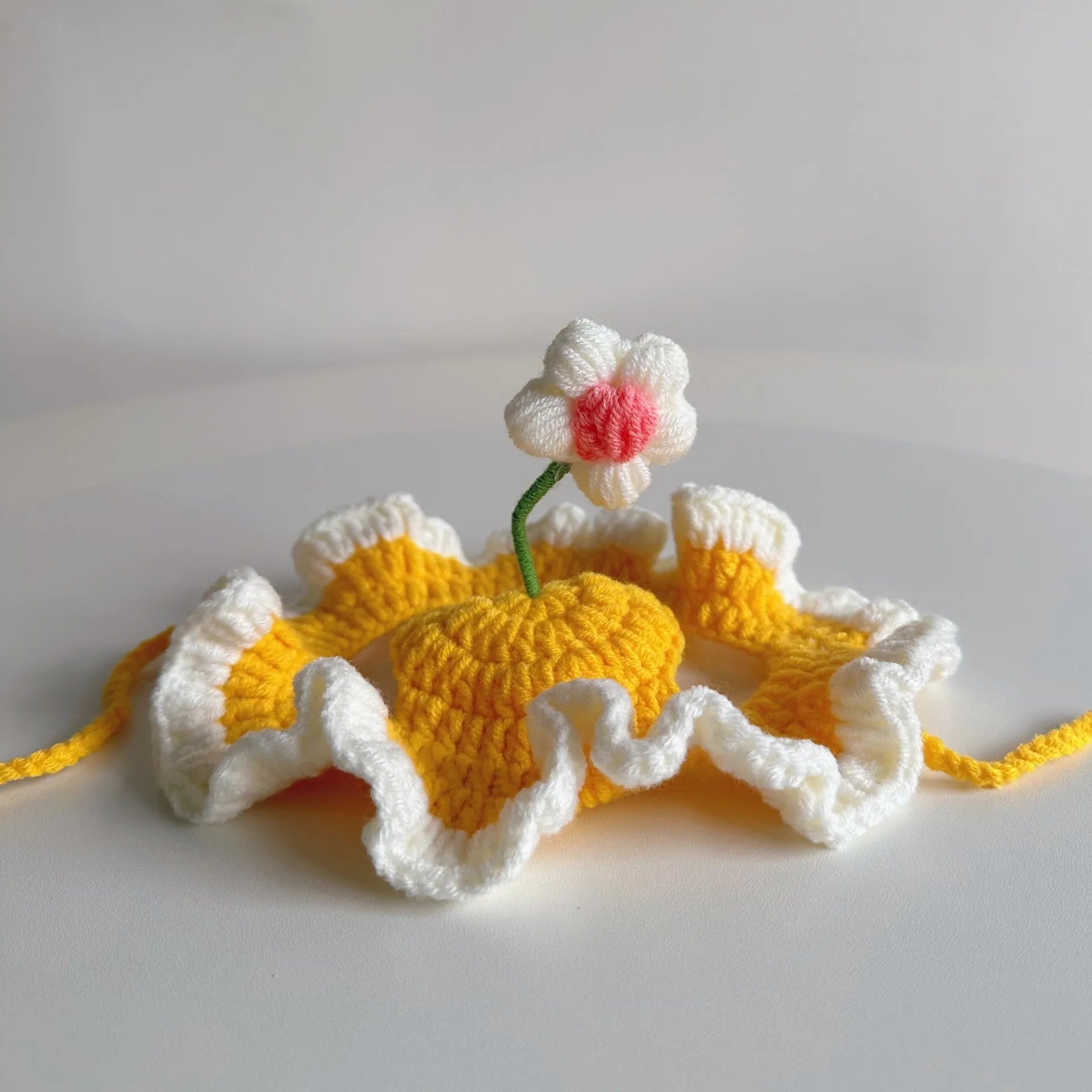 Knitted cartoon cat hat for small pets in green, pink, and yellow colours