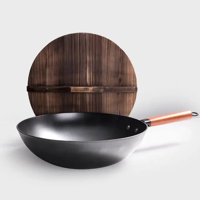 Black traditional iron wok pan with wooden handle and induction base
