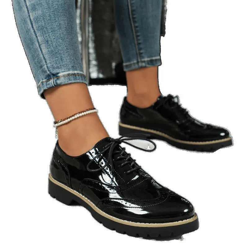 Women's black lace-up loafers with mirror sequins and a wedge heel, shown from the side.