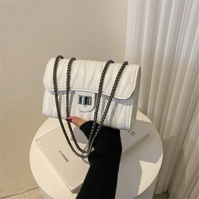 Small textured diamond pattern women's PU bag in a horizontal square shape with a single shoulder strap.