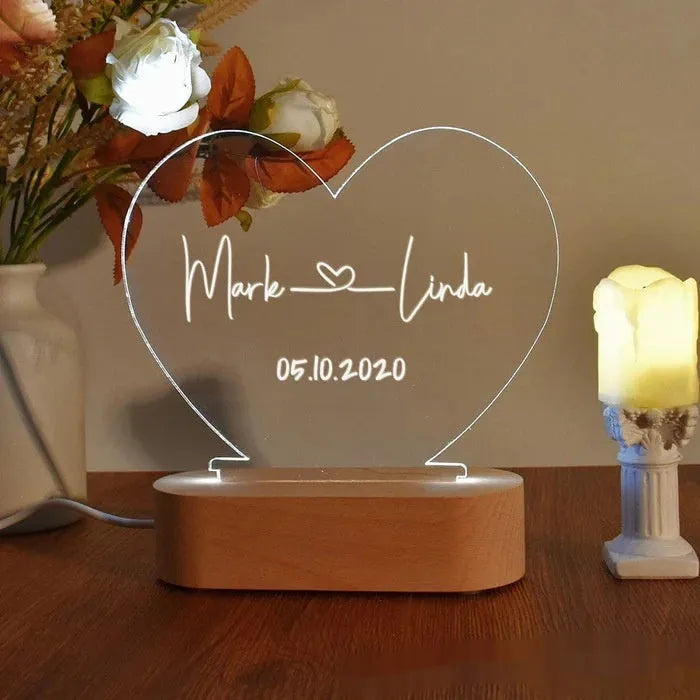 Custom transparent acrylic LED night light etched with personal names and date.