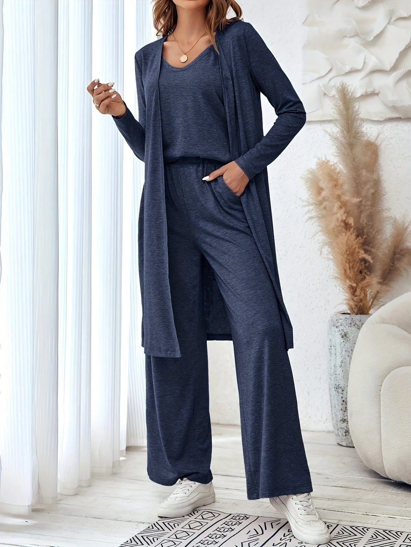 Blue women's three-piece suit set with top, trousers, and suspenders on a hanger