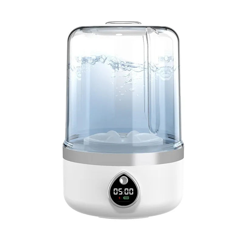 A compact white portable washing machine with USB cable on a countertop.