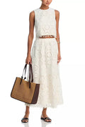 White women's retro-style two-piece suit with sleeveless top and embroidered long skirt.