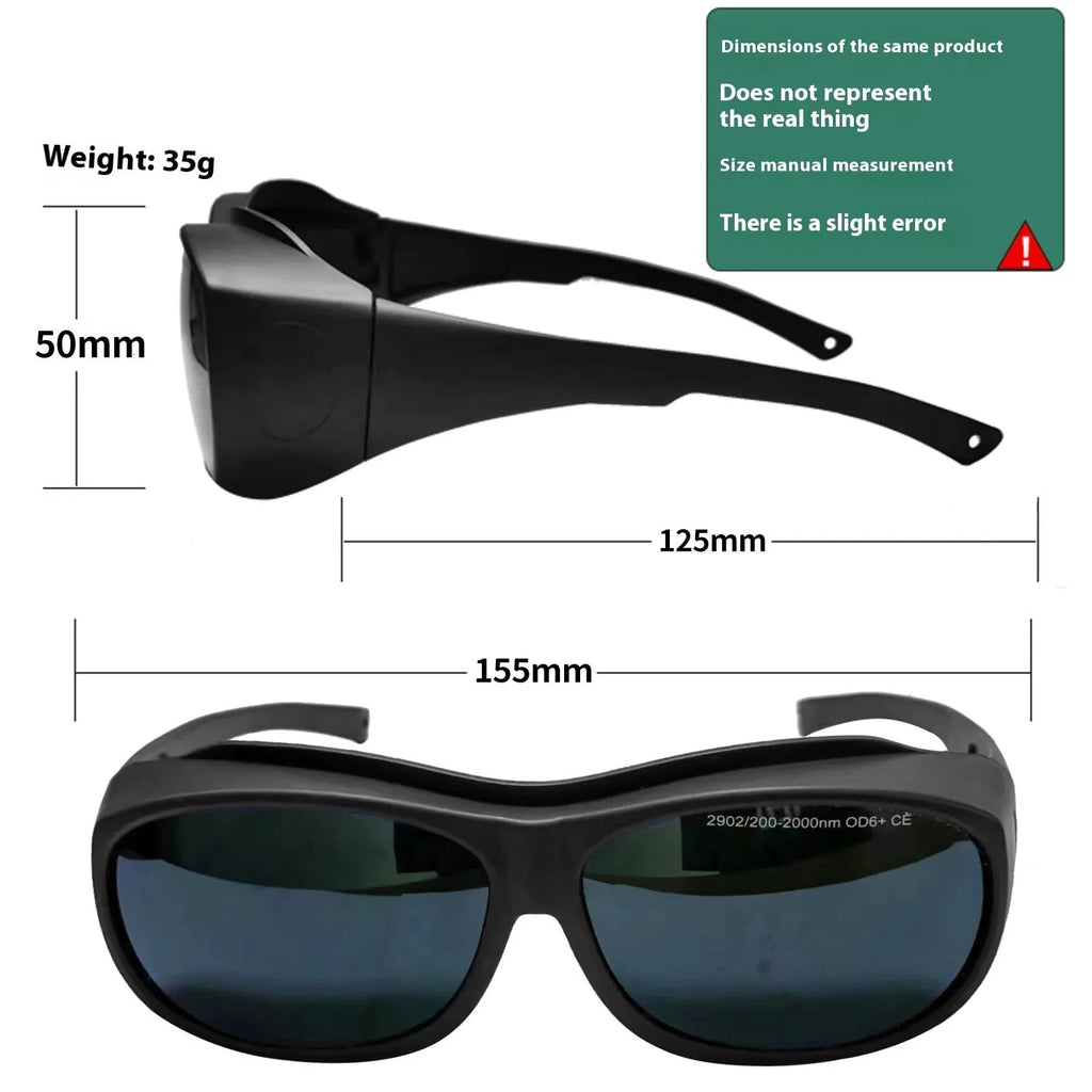 A pair of clear laser and welding safety goggles with a soft cleaning cloth on a dark background.