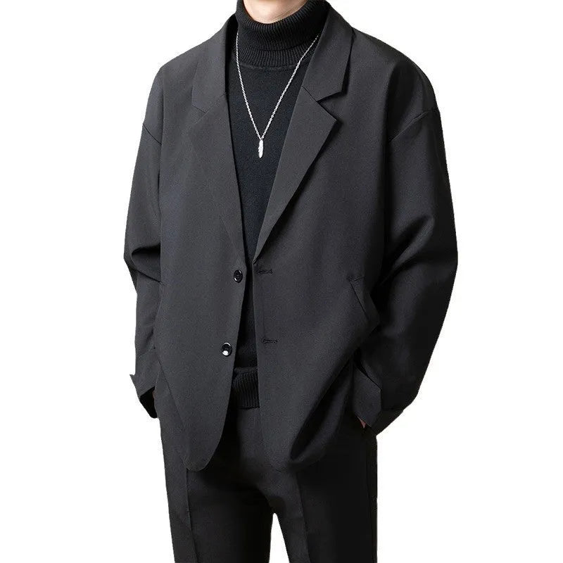 Man wearing a loose fit apricot coloured casual suit jacket with long sleeves.