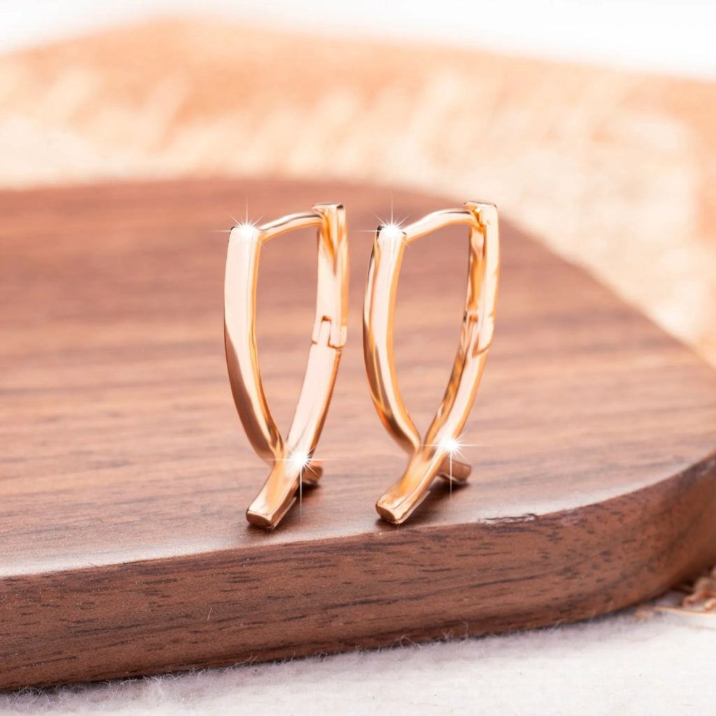 Rose gold coloured cross shaped earrings for women made from copper.