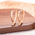 Rose gold coloured cross shaped earrings for women made from copper.