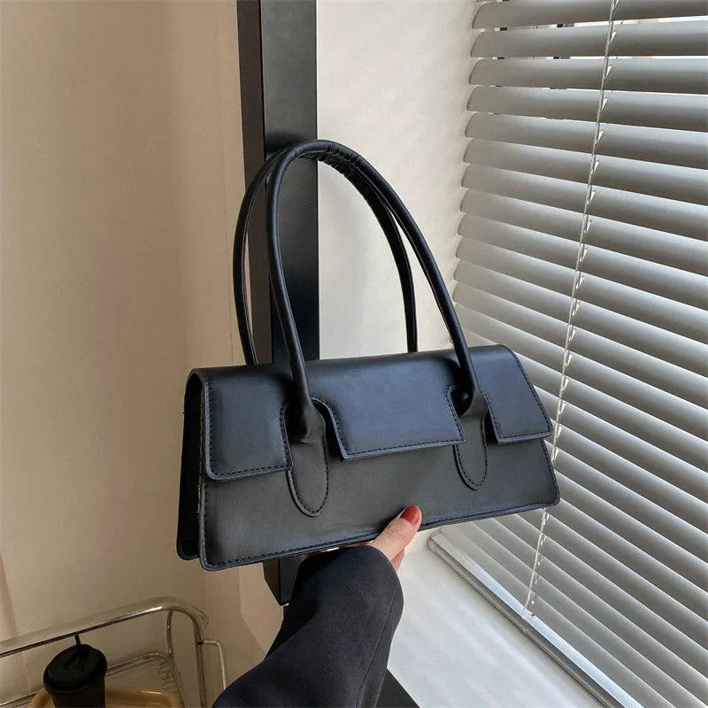 Women's small horizontal square shoulder bag in PU leather with single strap and stitching detail.