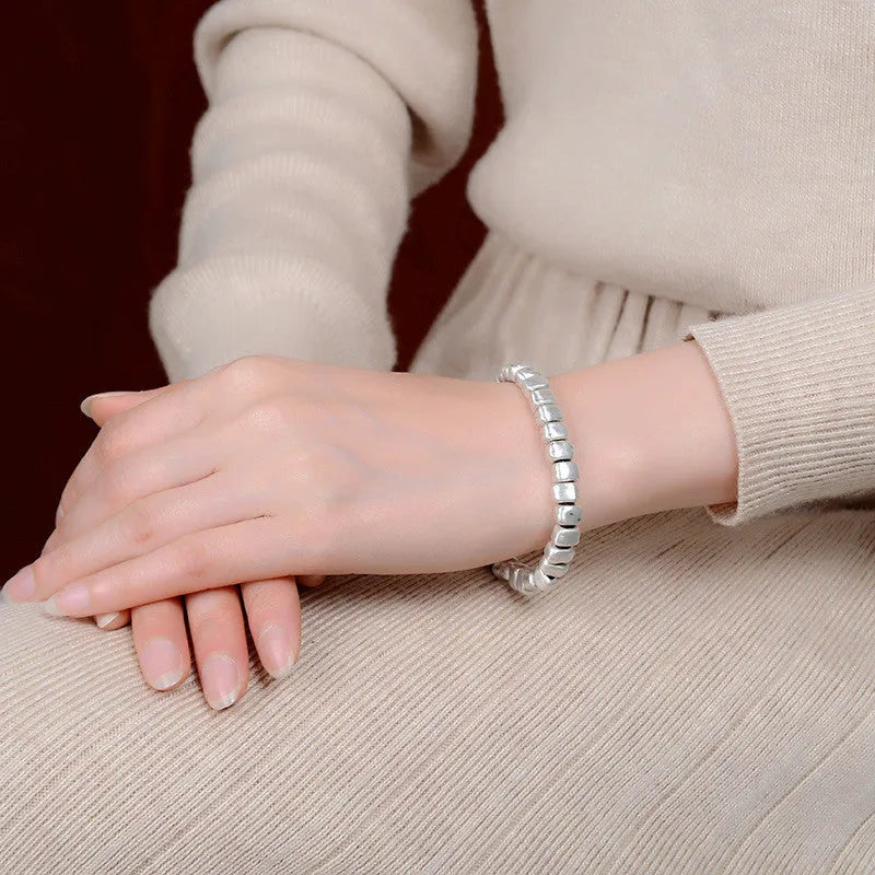 Handmade women's bracelet with silver squares and wooden beads on elastic cord