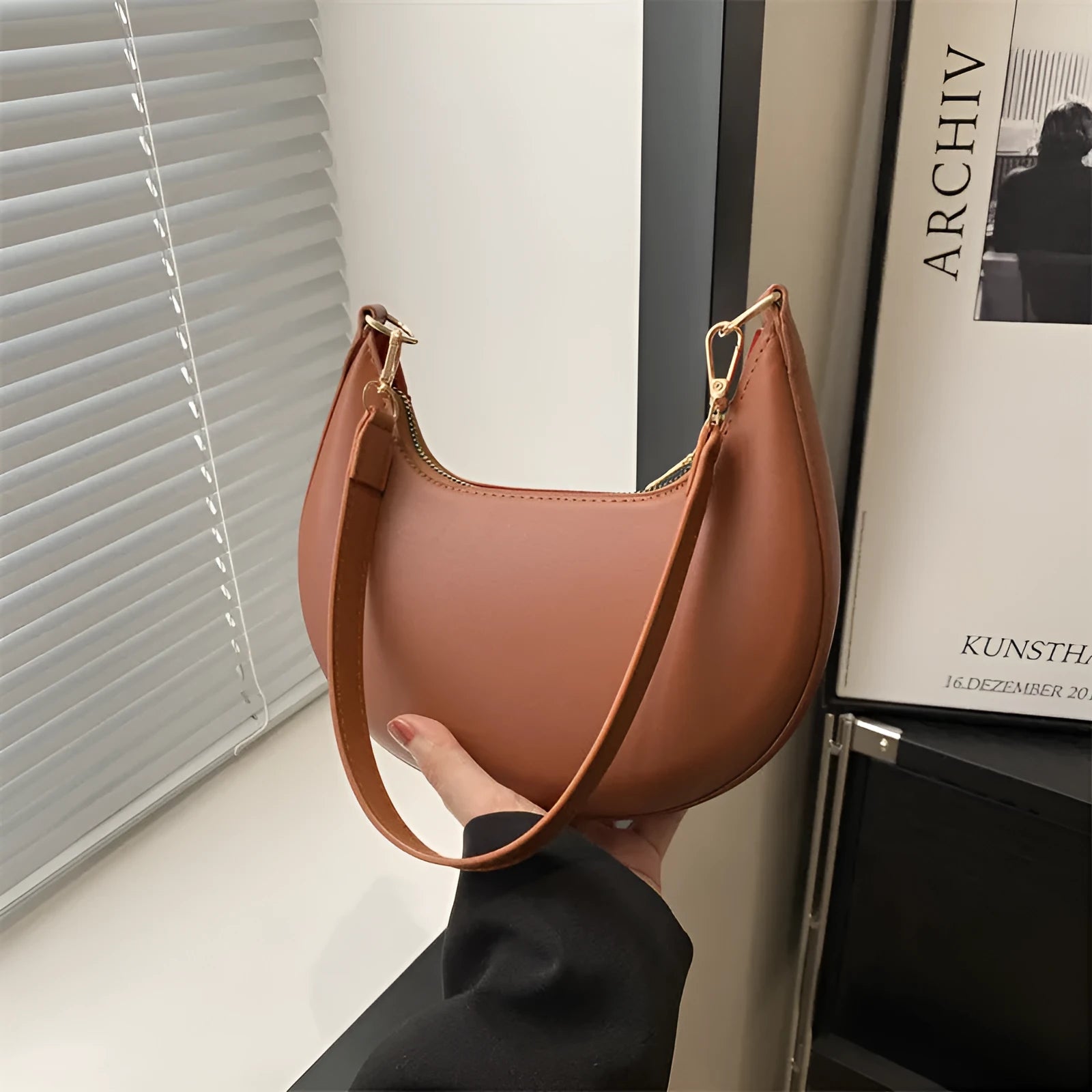 21cm round PU underarm bag with single shoulder strap in seven colour options showing mobile phone pocket