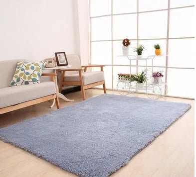 Soft white rectangular lambskin area rug with plush texture on a wooden floor.
