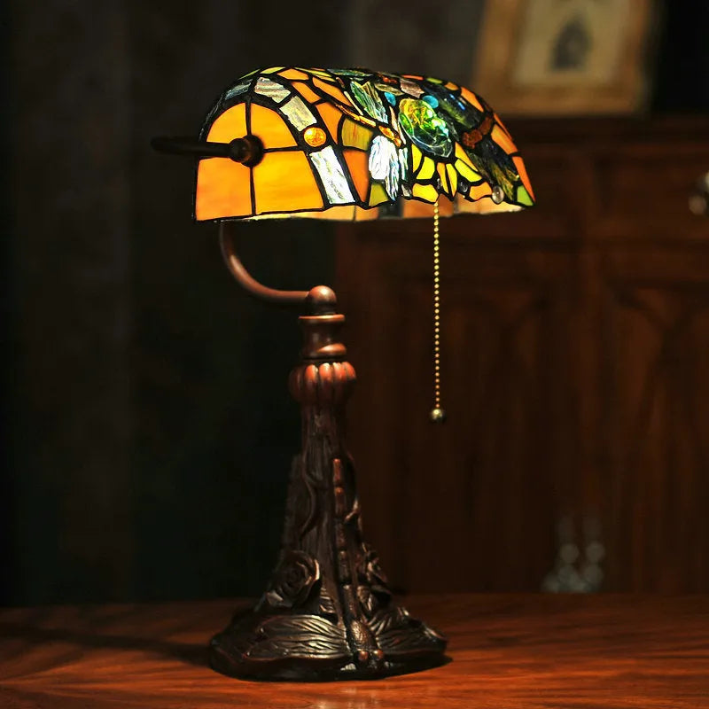 10-inch Tiffany style desk lamp with coloured stained glass shade and matching resin base on a wooden table.