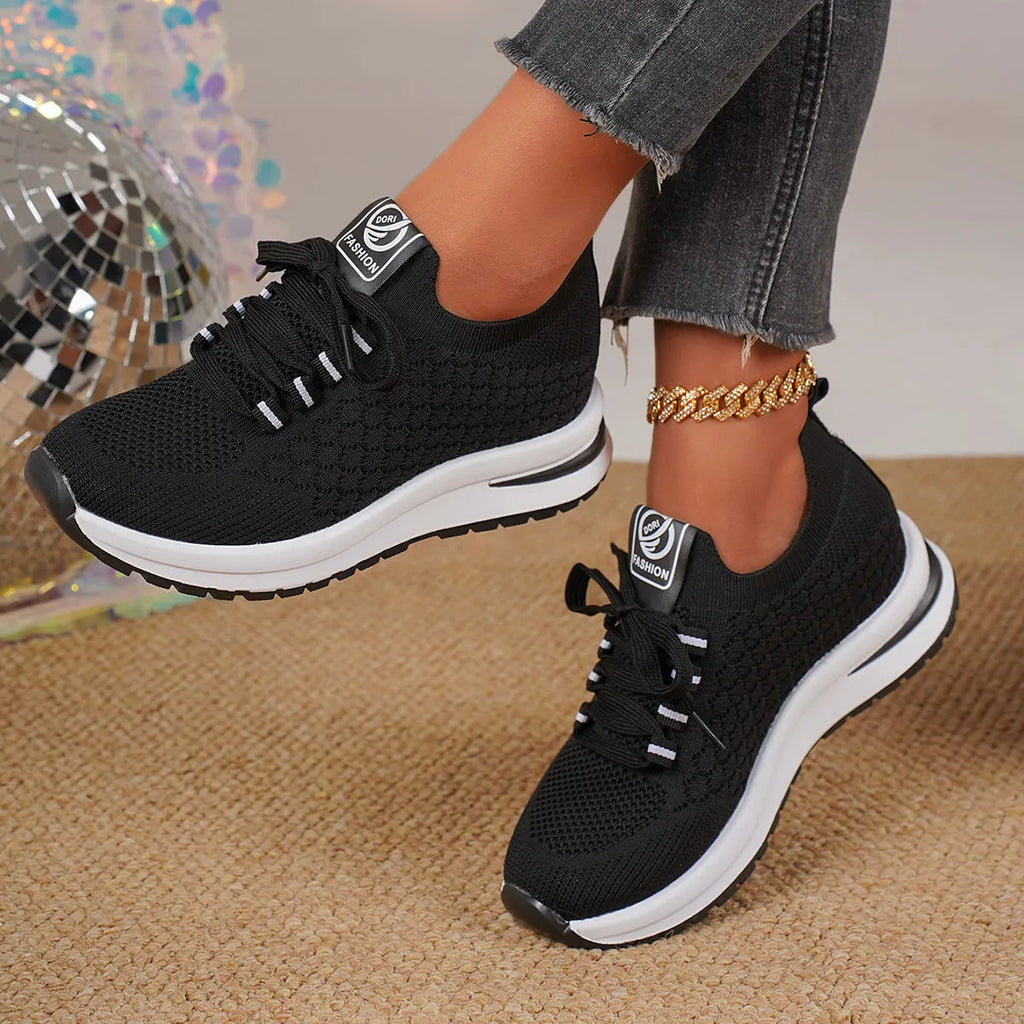 Women's black mesh lace-up flat platform sneaker on a white background