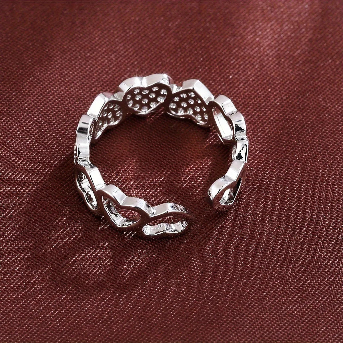 Gold or silver adjustable openable heart-shaped couples ring on a copper base.