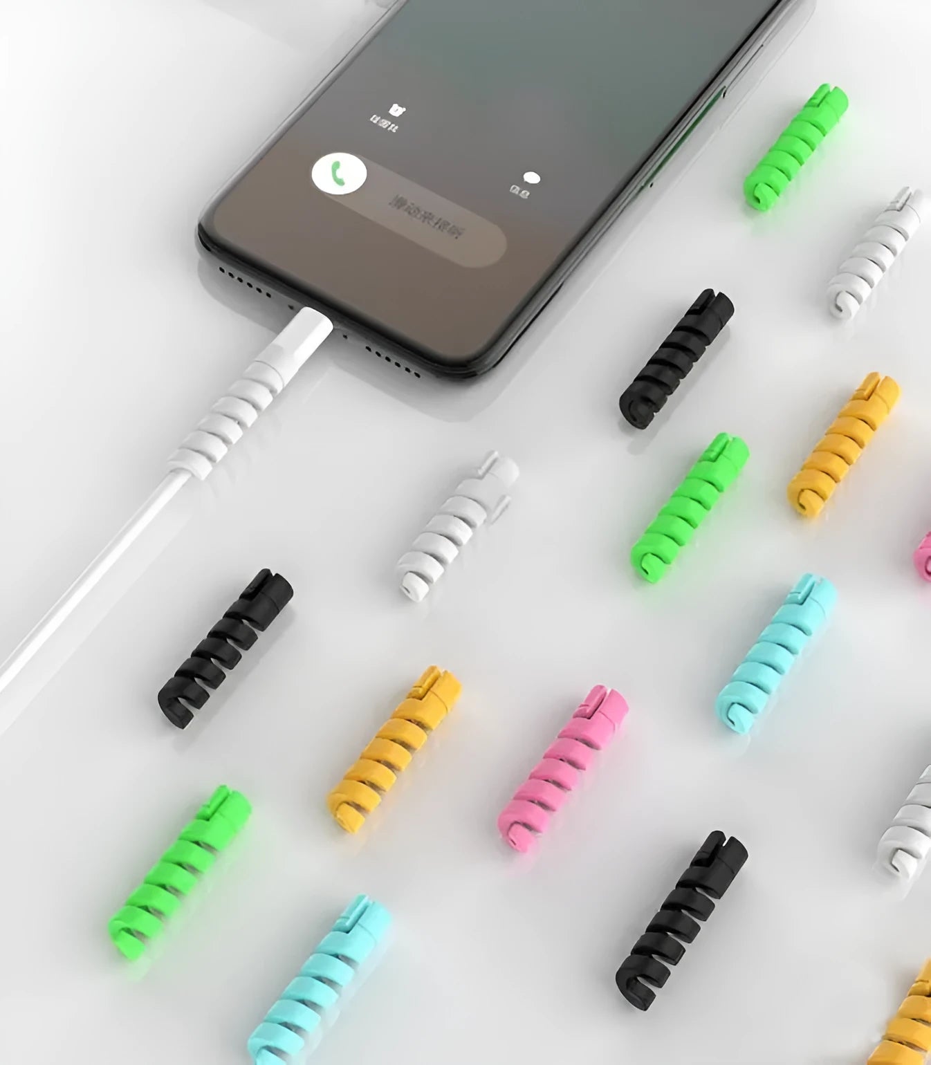 Plastic spiral charging cable protector in various colours next to a USB cable.