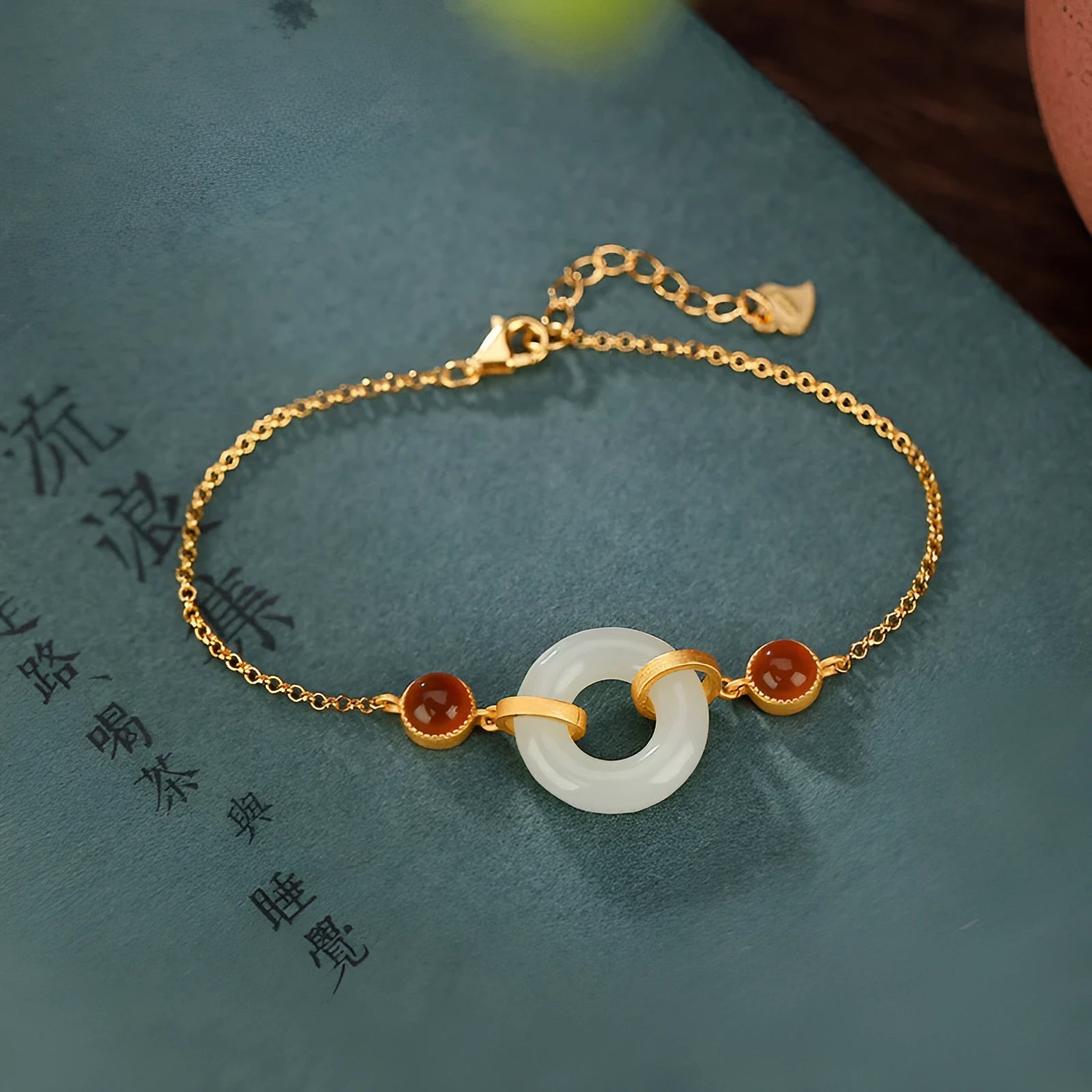 Gold-coloured women's bracelet with inlaid green Hetian jade stone and an adjustable peace buckle clasp.
