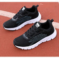 Women's low-top black and white running sneakers with cross-strap detail and MD sole.