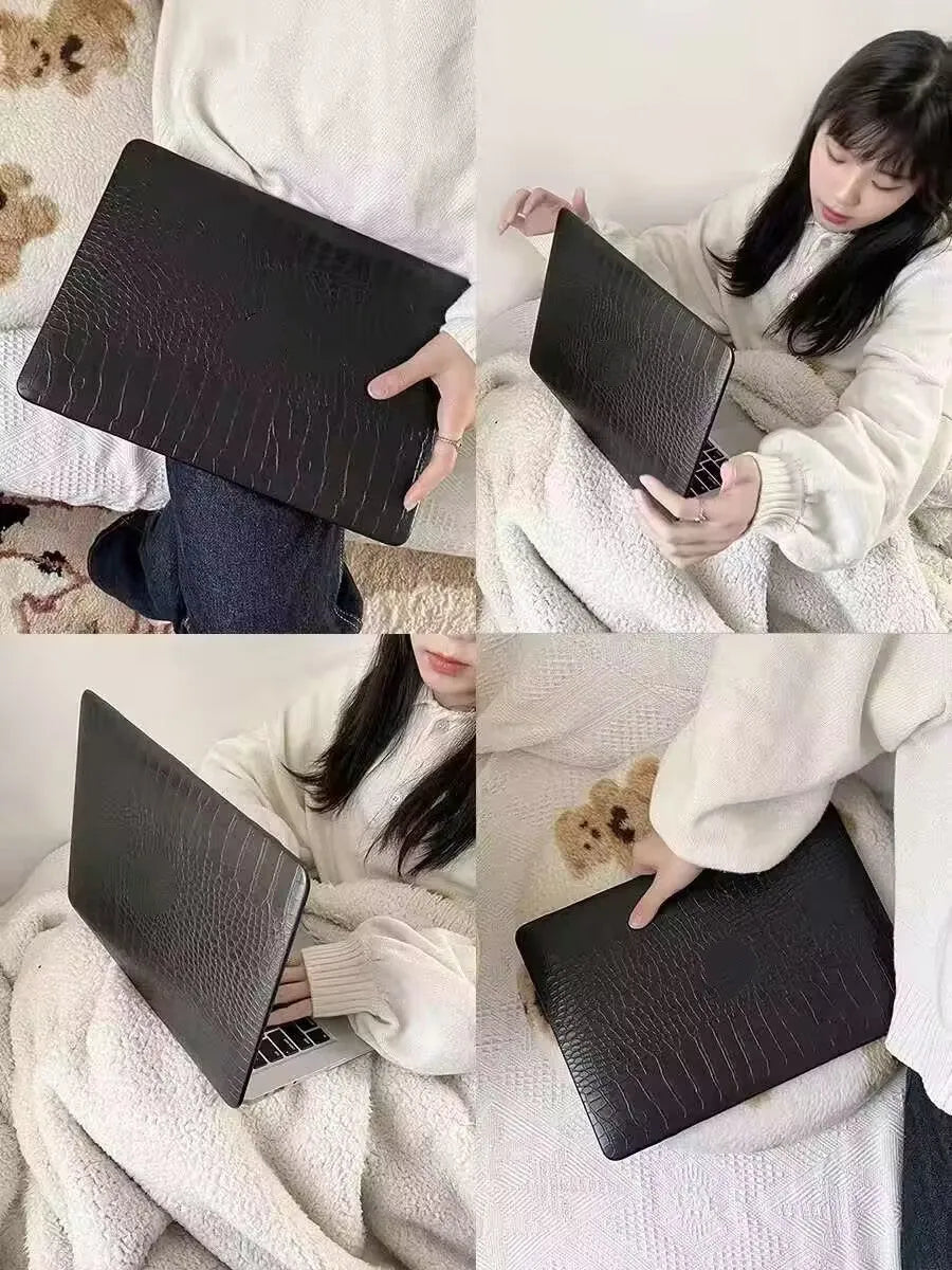 Black MacBook protective case with crocodile texture and visible Apple logo through a cutout.
