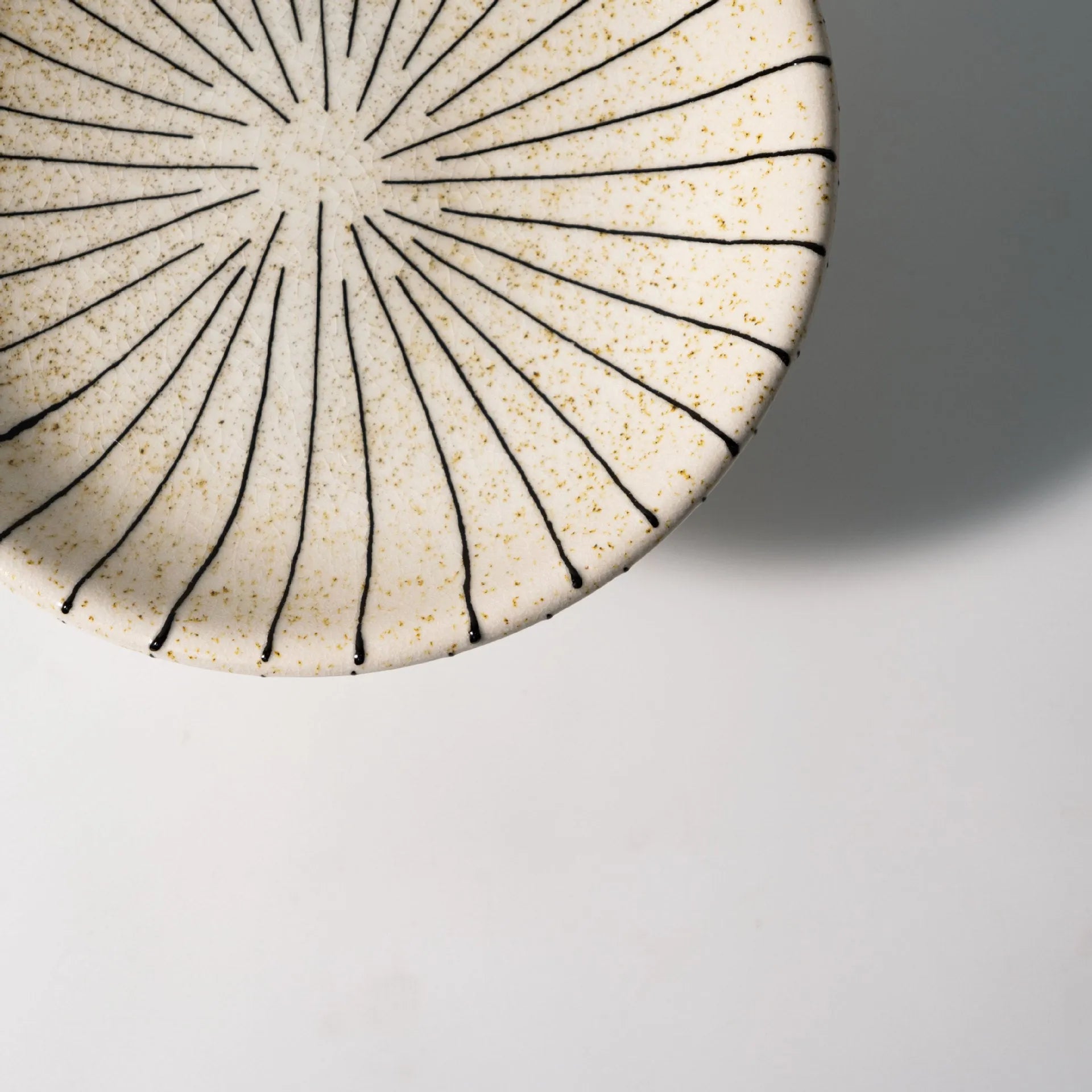 Black and white striped synthetic resin fruit plate on a table.
