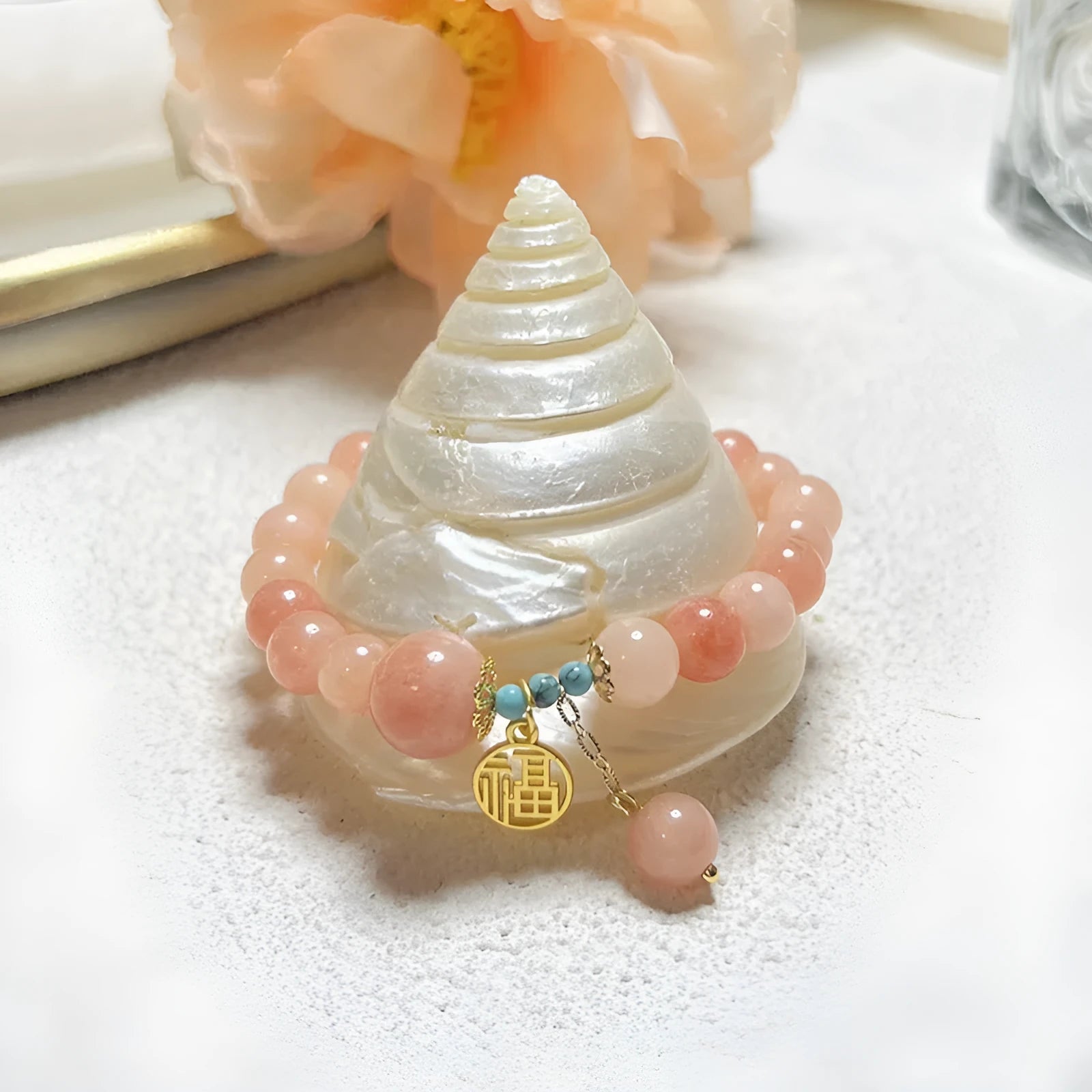 Close-up of a pink natural stone set within a simple silver-toned alloy women's bracelet.