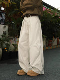 Men's loose straight-leg pleated trousers in apricot stripes on a mid-waist fit model.