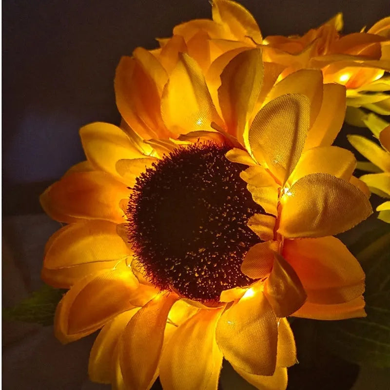 Rechargeable artificial sunflower LED night light on a table with USB cable.