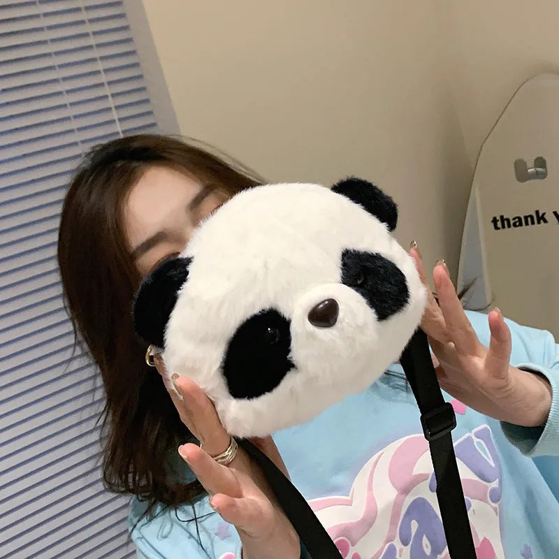 Soft plush cylindrical panda head crossbody bag with a shoulder strap.