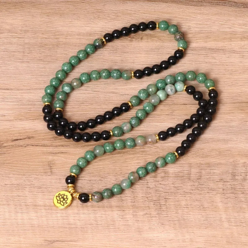 Green and black alloy bead elastic bracelet on a black stretch cord.