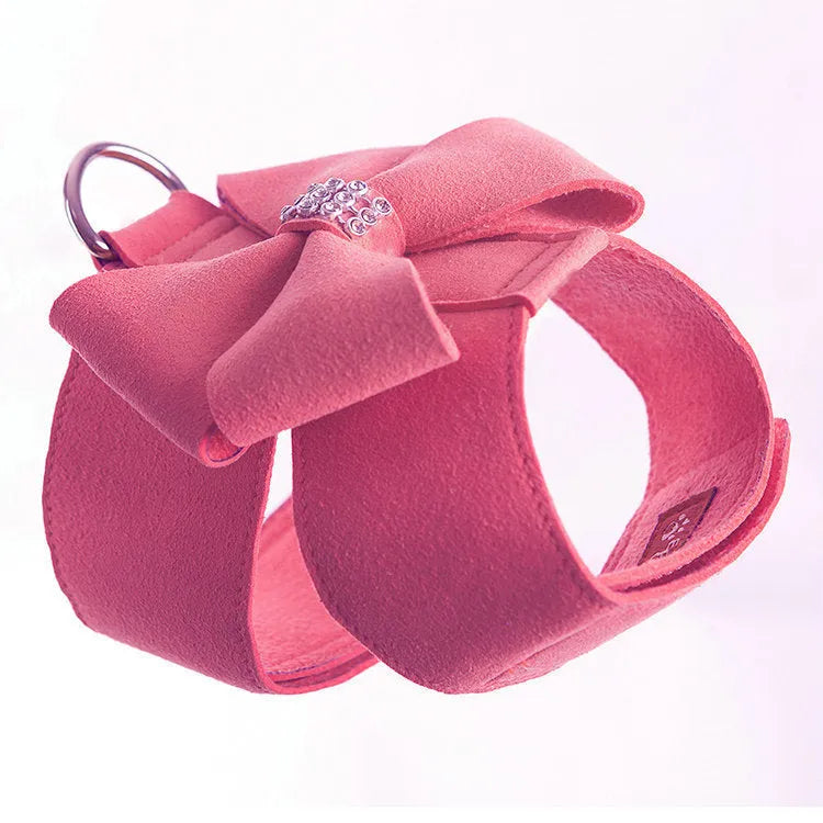 Pink adjustable dog chest strap with a cute bowknot detail, shown on a small puppy.