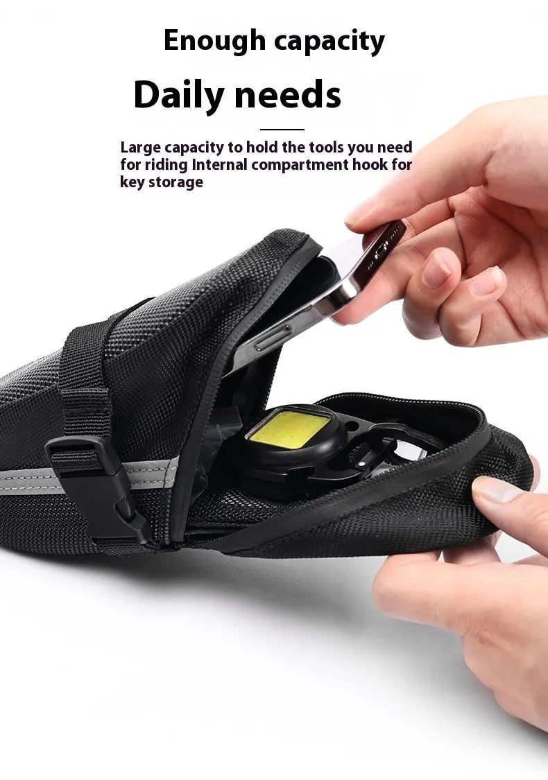 Black cycling tail bag mounted on mountain bike saddle with quick release fixture