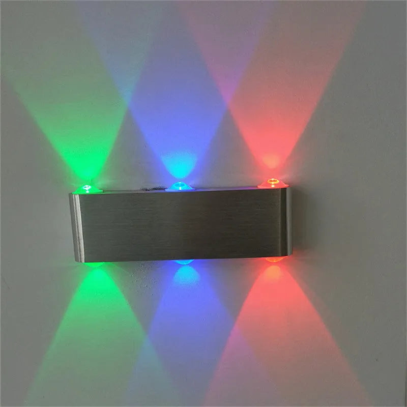 Silver aluminium rectangular LED wall lamp mounted on a wall, displaying multiple light colour options.