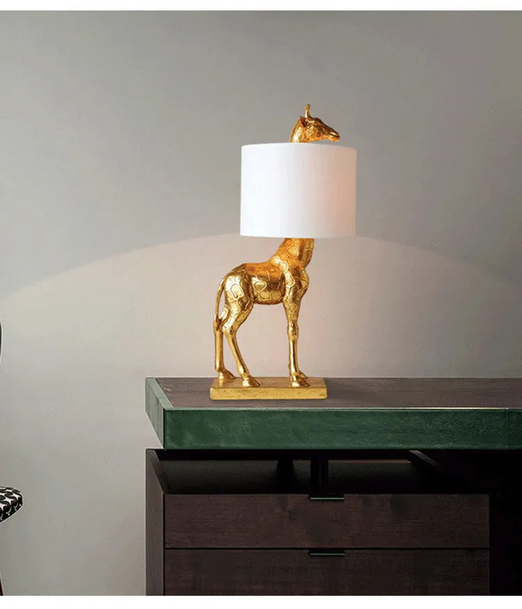 White or gold giraffe table lamp measuring 66cm tall with resin and cloth construction