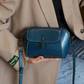 Women's brown oil-wax cowhide leather shell-shaped messenger bag with crossbody strap and visible sewing details