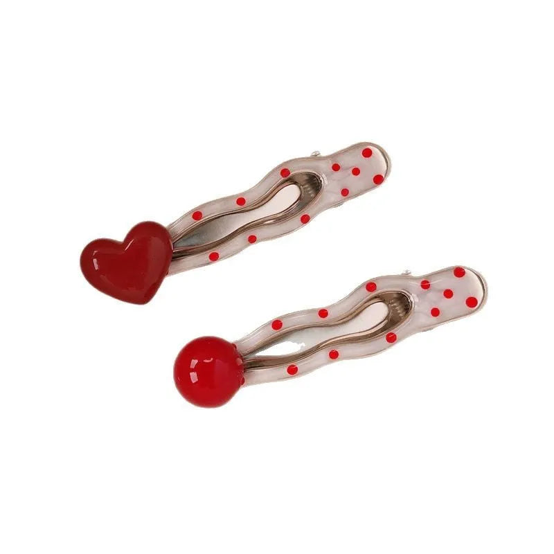 Red love heart shaped barrette hair clip with retro white dot design on black background
